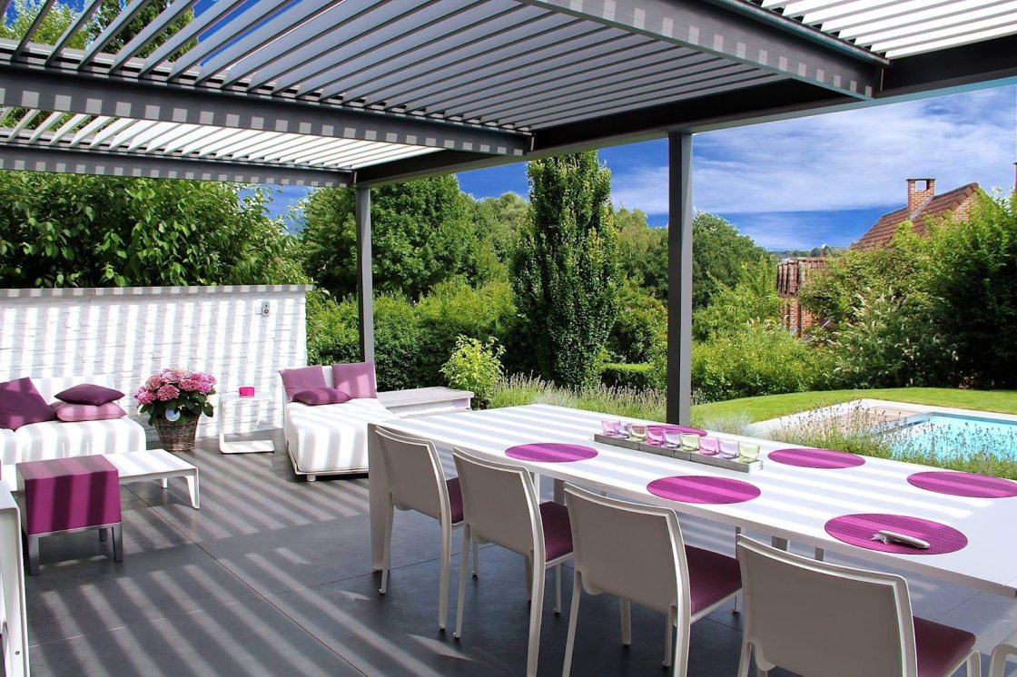 A gray louvered roof pergola over tables and chairs
