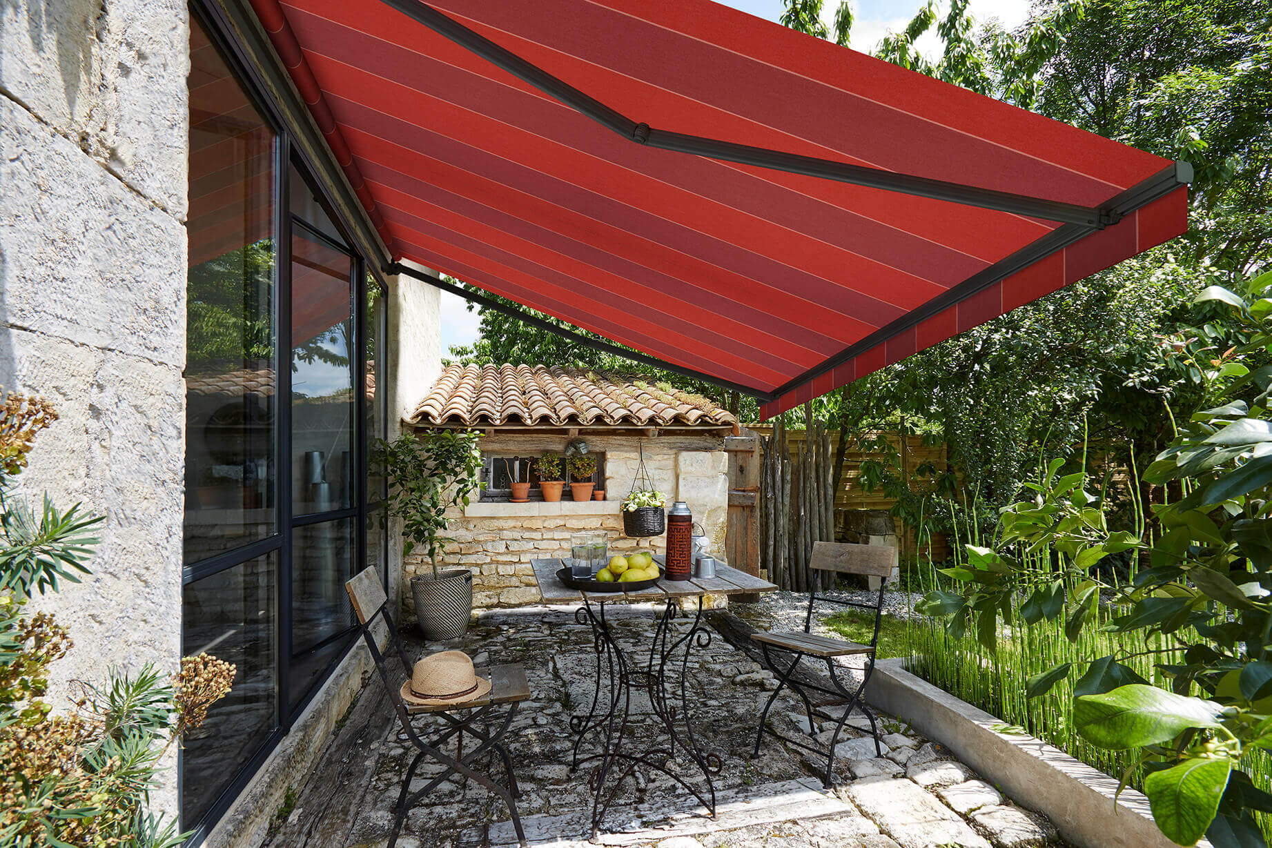 Red striped awning protecting wrought iron furniture