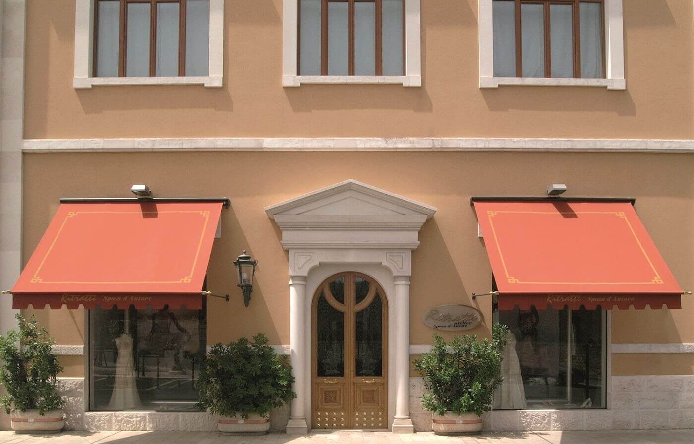 Brick colored side arm window awnings  on a commercial building