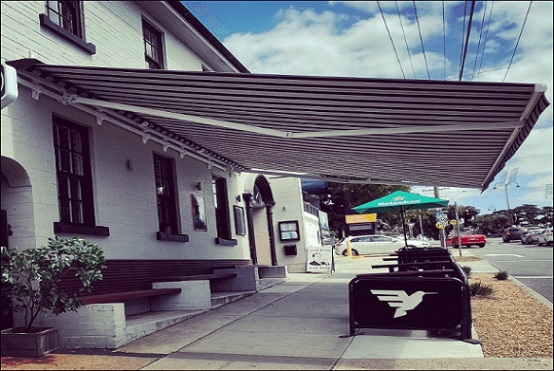 large projection commercial retractable awning over a sidewalk