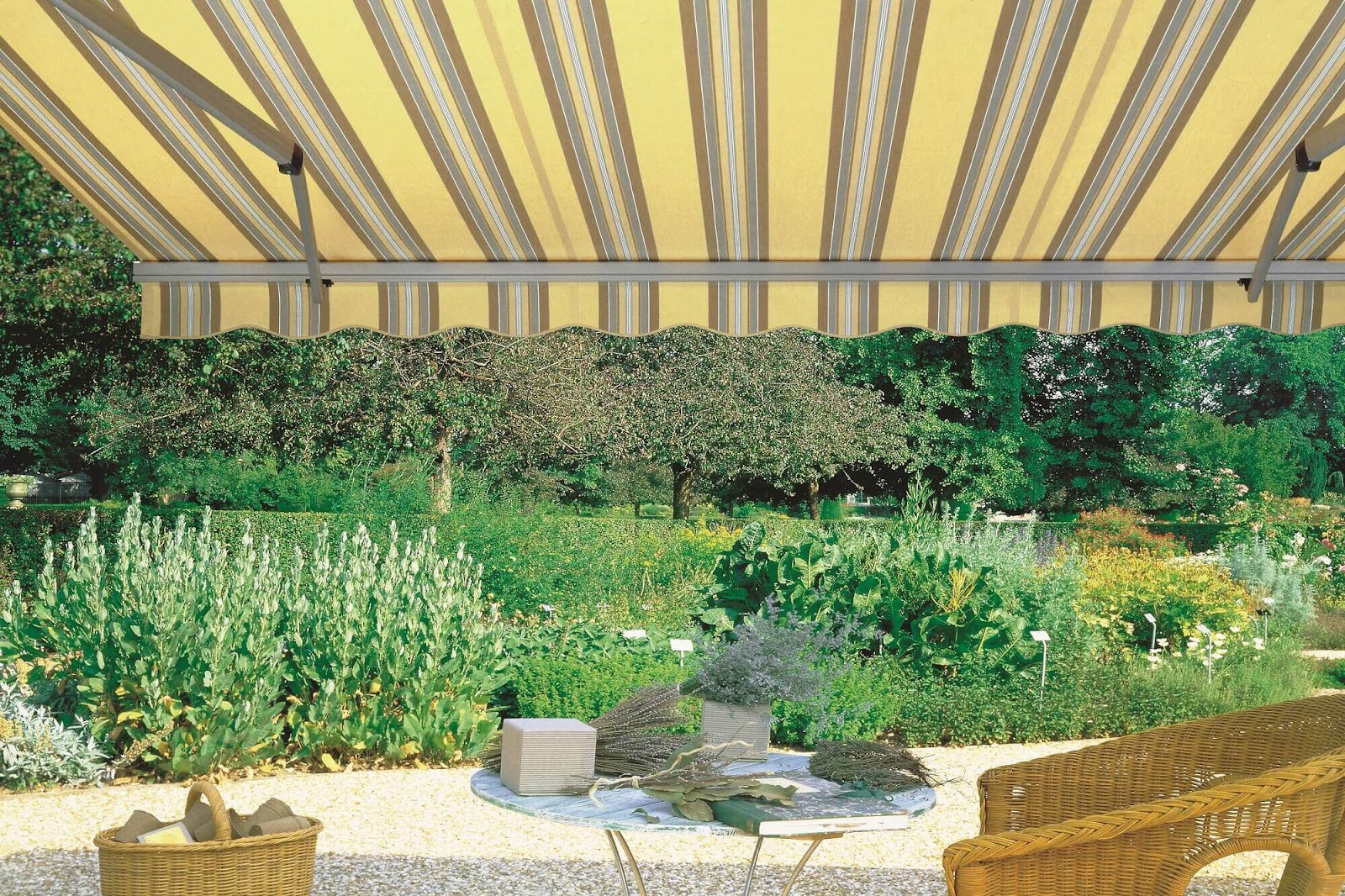 Striped retractable folding arm awning in a garden